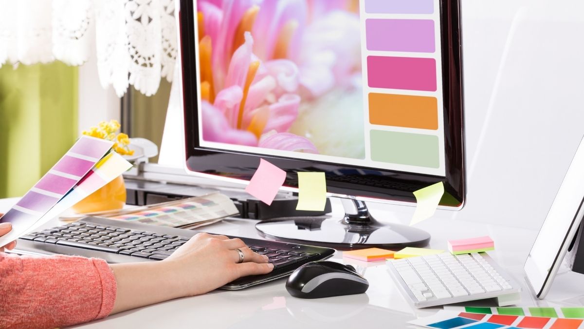 graphic designer working on computer with colourful post-it notes