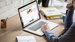 man sat at desk using laptop