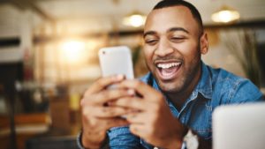 black man laughing at phone